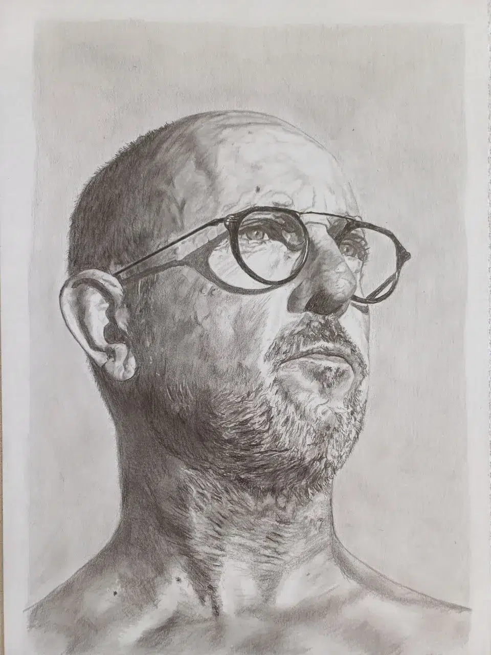 Retrato a lápiz de un hombre calvo con gafas redondas y barba corta, con gesto pensativo