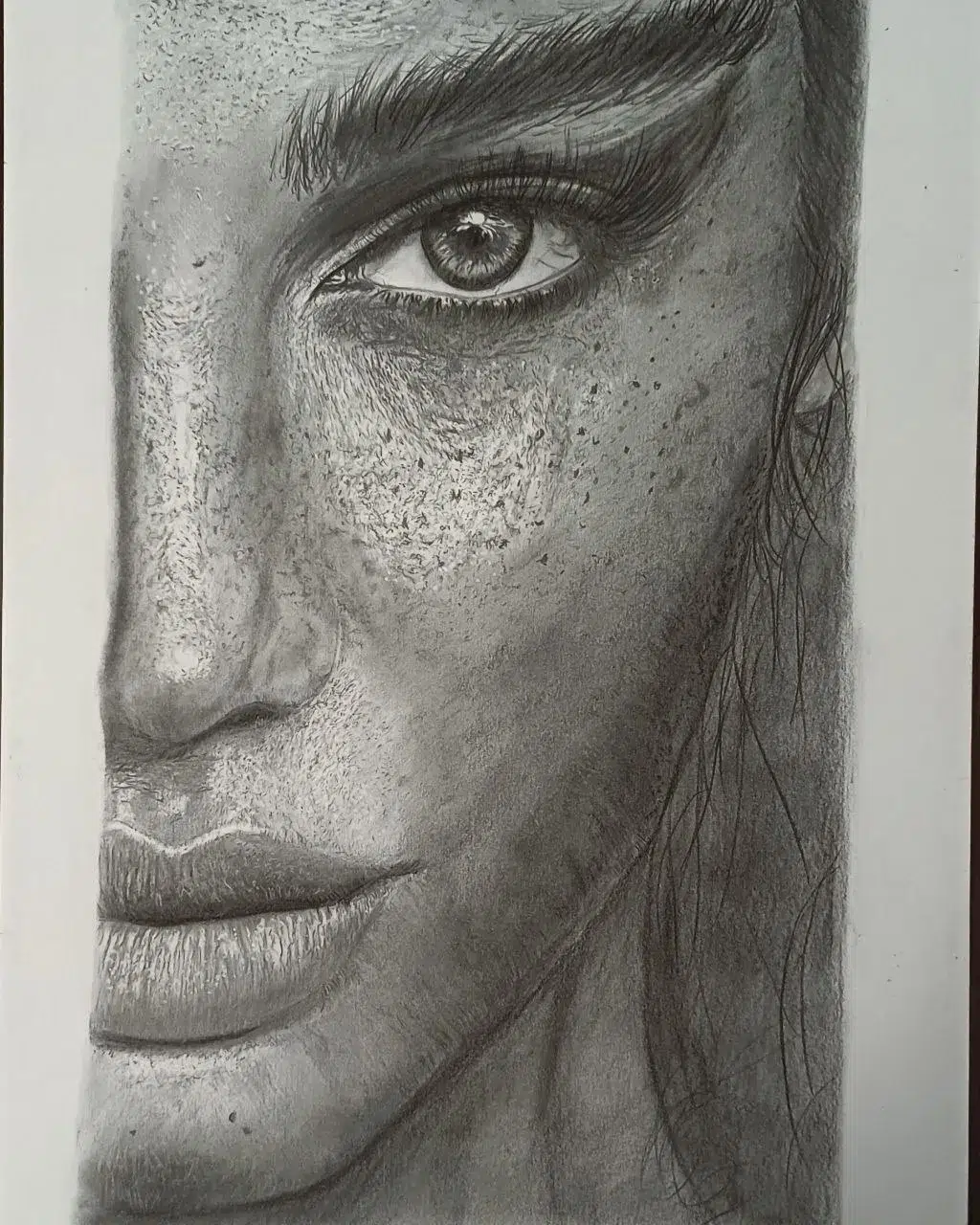 Retrato a lápiz de primer plano de media cara de una mujer con abundantes pecas